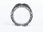 Side view of the BIOORGA silver ring showing the circular opening and sculpted alien-inspired relief.