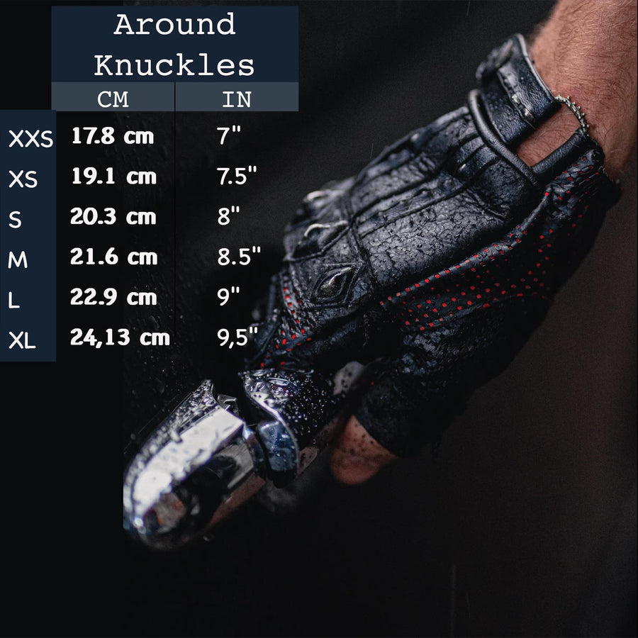Close-up of a gloved hand gripping a motorcycle handle. A size chart overlays the left, displaying hand measurements in centimeters and inches for sizes XXS to XL, ranging from 17.8 cm to 24.13 cm (7" to 9.5"). The Kaya Movement Custom Dragon Scale Leather Gloves, Fingerless Motorcycle & Driving Gloves are rugged and detailed, perfect for motorcycle enthusiasts with a gothic fashion flair looking for post-apocalyptic and stagewear accessories.