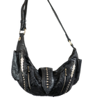 The Kaya Movement's Nebula Unisex Leather Off Shoulder Cross Body HandBag is perfect for dystopian festivals. This bag, featuring a black leather finish with a shoulder strap and silver stud accents, is designed with two front zippered pockets and decorative stitching along the sides. The textured surface combines smooth and patterned leather sections, highlighting the artistry of custom leather goods craftsmanship.