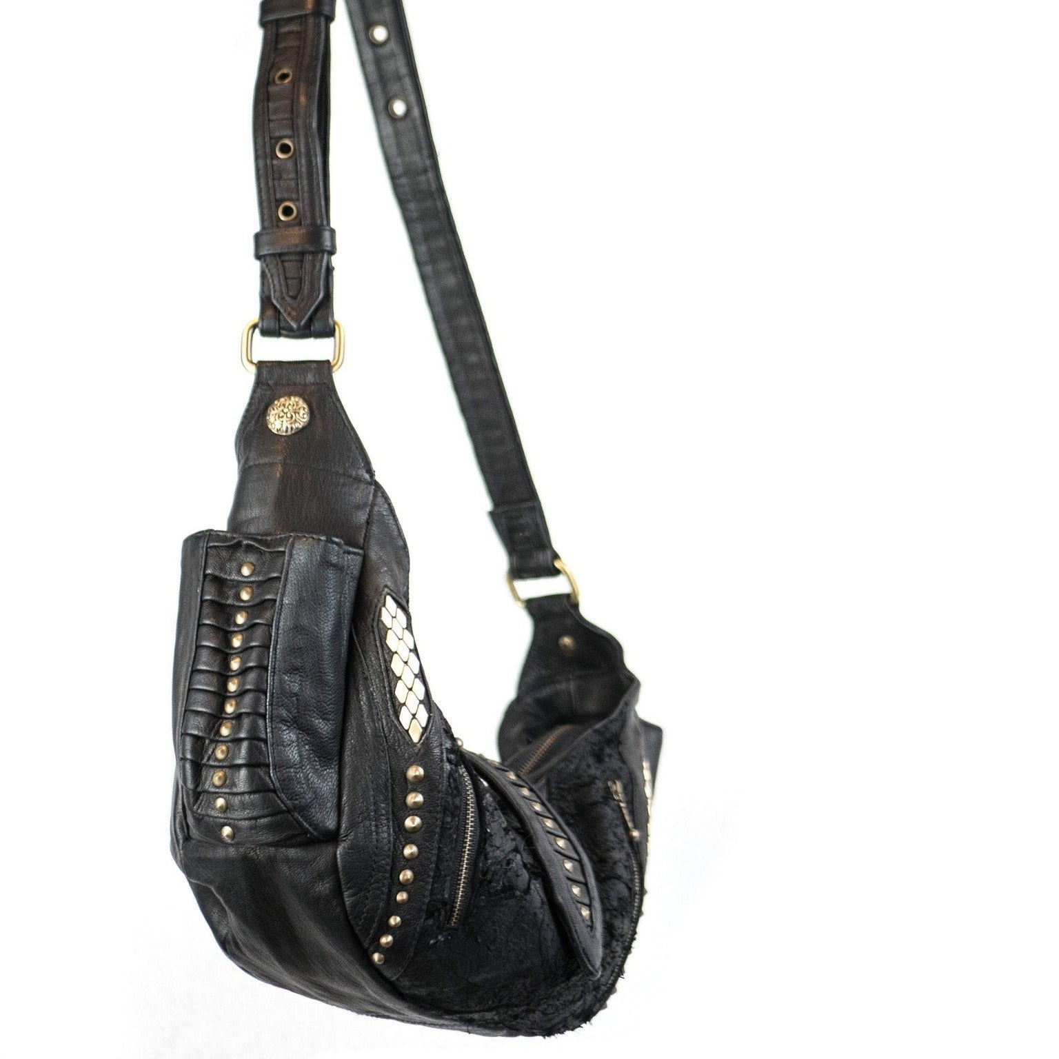 Image of the Nebula Unisex Leather Off Shoulder Cross Body HandBag by Kaya Movement. This custom black leather bag features a wide strap adorned with gold studs and decorative stitching. It also includes a flap with a gold button and intricate front details, such as metallic diamond-shaped accents. Perfect for events like dystopian festivals, where bold style is essential.