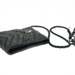 A Kaya Movement AMONI Black Stud Bi-Fold Flip Leather Wallet with a Labradorite accent is displayed. This wallet, inspired by futuristic cyborg design, features an intricate woven pattern and gold accents, appearing small in size and suitable for carrying essentials. The white background provides a clear view of the wallet's details.