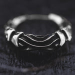 A close-up image of the PROMETHEUS Small Cyborg Hoop Earrings in 925 Silver by Kaya Movement, showcasing their intricate design with twisted and interwoven metal bands reminiscent of post-apocalyptic body jewelry. The earrings have a slightly rustic and textured appearance, set against a dark, blurred background that emphasizes their detailed craftsmanship.