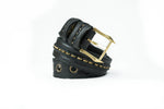 A coiled ITO Punk Rock Men's Black Studded Leather Belt by Kaya Movement, featuring a gold buckle and adorned with metallic studs along its length, is displayed against a plain white background. Ideal for dystopian festival wear, the belt's texture and design details are highlighted.