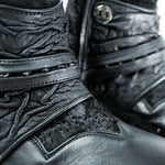 Close-up of a pair of MAGMA Wasteland Studded Leather Ankle Combat Boots by Kaya Movement, showcasing their textured, wrinkled detailing and multiple straps including a studded strap and one with a button closure. The intricate design and stitching are prominently featured.