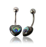A pair of 14 gauge Heart Belly Piercing Rings in Silver from Kaya Movement, featuring curved barbells with heart-shaped ends adorned with iridescent blue-green peacock feathers and round silver balls crafted from 316L surgical steel on the opposite ends. The jewelry is polished and reflective, displayed against a white background.