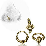 A sketch of a nose adorned with the Kaya Movement's AVA Lotus Flower Seamless Nose Ring in Gold (20 gauge), featuring three detailed variations of simple body jewelry beside it. Each gold nose ring showcases a lotus flower design accented with small beads.