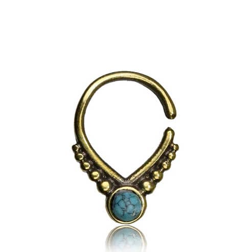 A decorative gold septum ring with an open design, featuring a beautiful opal at its center. The ring has small gold beads on either side of the stone, arranged symmetrically in a triangle shape. The reflective surface underneath creates a faint mirror image of the ring, reminiscent of elegant 18g jewelry from Kaya Movement's Unique Gold Triangle Septum Ring collection. This piece exudes a cute witchy goddess vibe with its oxidized gothic aesthetic.