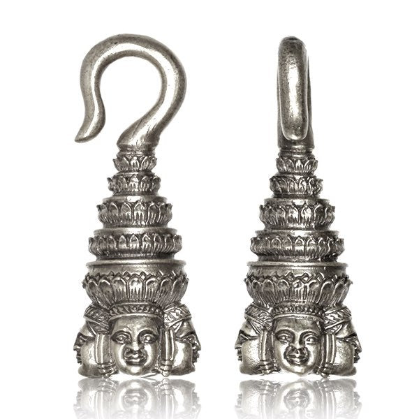 The ANGKOR WAT Heavy Ear Weights in Silver from Kaya Movement are 6 gauge ear weights with hooks that feature intricate carvings reminiscent of temple architecture, including Buddha faces at the base. These silver white brass ornaments have multiple tiers and manifest a traditional, artistic style reflective of tribal piercing body jewelry traditions.
