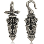 The JUSTIN Ear Weights in Silver 4mm (6 gauge) by Kaya Movement are intricately designed with detailed engravings and pointed tips. Made from white brass, these ear weights have a symmetrical shape resembling miniature daggers or ceremonial artifacts, adorned with ornate tribal patterns covering their surfaces.