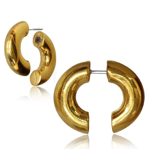 The ELI Fake Hoop Gauge Earrings in Gold with a 925 Silver Post by Kaya Movement feature a chunky, crescent shape design. Crafted from yellow brass, these earrings boast a polished, reflective surface and are secured with a post back closure. The image showcases one earring from the front and another from an angled perspective.