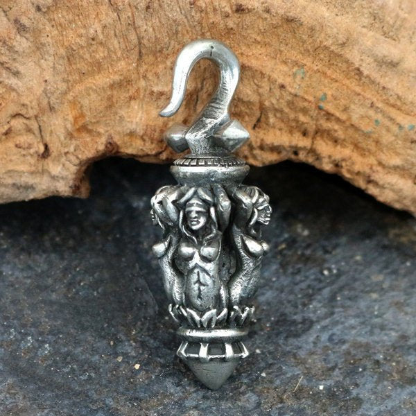 The JUSTIN Ear Weights in Silver 4mm (6 gauge) by Kaya Movement feature an intricate design depicting a relief of a female figure with raised arms, reminiscent of tribal art. These ear weights include a hook at the top for easy attachment and are showcased against a rustic wooden background.