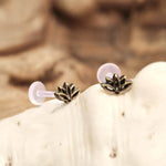 The LOTUS Labret Stud in Gold, a small and intricate piece of body jewelry by Kaya Movement, features a tribal ethnic lotus design with metallic finishes and clear plastic backings. Displayed on a light, textured surface with a softly blurred background, the exquisite details of this gold brass 16 gauge stud are beautifully highlighted.
