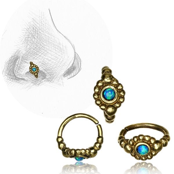 Three gold nose rings, each featuring a small greenish-blue gemstone, are displayed. In the background, a sketch shows a side view of a nose with one of Kaya Movement's SHA Beaded Flower Nose Rings in Gold & Black Onyx (20 gauge) positioned on the nostril.