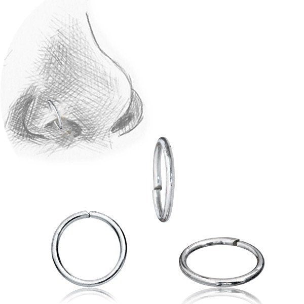 A sketch of a nose with a nose ring in the nostril is shown in the upper left corner. Three INDUS Seamless Minimalist Hoop Rings in Silver by Kaya Movement, crafted from 925 silver body jewelry and designed at 20 gauge, are displayed against a plain white background. These rings feature a minimalistic design, come in various sizes, and are perfect for multi-use piercing.