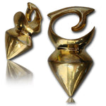 Gold-colored metal ear gauges shaped like cones with a hook design at the top, reflecting light and positioned against a white background. These DAYAK Heavy Tribal Ear Weights in Gold | 0 gauge by Kaya Movement exude elegance while serving as versatile unisex gauge earrings, perfect for those who appreciate tribal piercing jewelry.