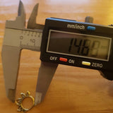 A digital caliper displaying a measurement of 14.80 mm is positioned above the MAWAR Lotus Flower Septum Ring in Silver by Kaya Movement, which is an 18-gauge decorative piece. The ring, resembling tiny hoop earrings often crafted from 925 silver body jewelry, features a petal or leaf-like design around its perimeter. Both items rest on a wooden surface.
