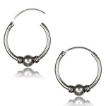 Introducing the Huggie Hoop Earring Pair by Kaya Movement, available in silver 925 and offered in both small and large sizes. These elegant hoops feature a central silver bead flanked by two smaller rings on each side. The polished surface reflects beautifully below, evoking the simple yet sophisticated essence of traditional ethnic body jewelry.