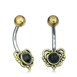 Introducing the DORE Butterfly Belly Bar by Kaya Movement, a stunning piece of navel jewelry designed with a curved barbell and crafted from high-quality surgical steel. This 14-gauge gold belly bar features an intricate butterfly charm, which houses either a dark round natural turquoise stone or an onyx at its center. The charms are elegantly attached to silver curved bars topped with delicate small round gold balls.
