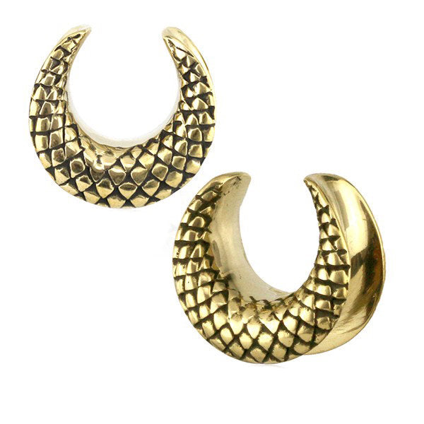 Close-up of two Kaya Movement Dragon Scale Horseshoe Saddle Tunnels in Gold. Each tunnel showcases a textured, reptile skin pattern on the outer surface, giving them a unique appearance. The tunnels are shiny and reflect light beautifully.