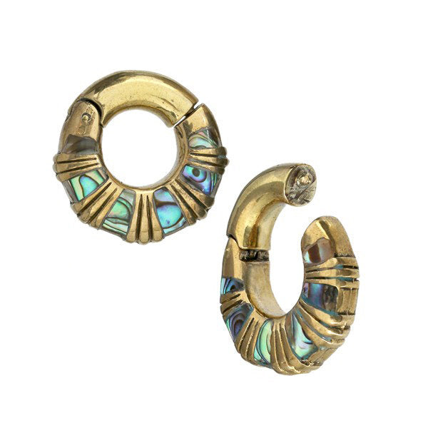 The AVI Clicker Hoop Ear Weights in Gold & Abalone Shell by Kaya Movement are crafted from gold brass and embellished with segmented, colorful abalone shell inlays. Each ear weight features intricate detailing and a small hinge, giving them a unique, luxurious appearance perfect for those who appreciate finely crafted abalone shell body jewelry. Available in 2 gauge size.