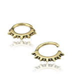 The SPIKE Punk Spike Nose Ring in Gold by Kaya Movement features gold faux septum rings with spiked designs that are symmetrically arranged around the lower half. The open-ended design allows for easy wear, while the spikes add a bold, edgy look. Crafted from gold brass body jewelry, these 16 gauge pieces make an impactful addition to your collection.