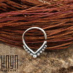 A Triangle Sterling Silver Nose Septum Ring with decorative small dot embellishments is exhibited against a rustic brown woven background. The brand name "Kaya Movement" is displayed in the bottom left corner of the image.
