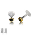 A pair of KEA Labret Stud earrings in gold and onyx featuring black onyx stone centers, surrounded by gold-tone rims with clear posts. Set against a plain white background, the brand logo "Kaya Movement" is displayed in the bottom left corner.