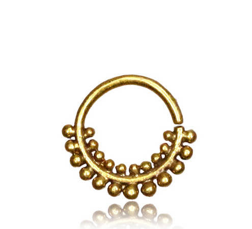 The ELE Seamless Ring in Gold from Kaya Movement features an intricate, beaded tribal ethnic design along the lower half of its circle. Crafted for easy use with an open clasp at the top, this 18-gauge piece is a versatile addition for multi-use piercings.