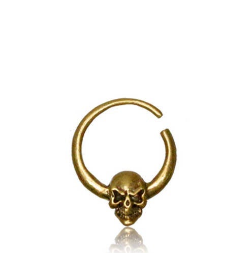 The SKULL Gothic Septum Ring in Gold by Kaya Movement is an 18 gauge, gold-colored nose ring featuring a detailed skull with two curved horns on either side. The open-ended design allows for easy insertion, and its bold, intricate craftsmanship highlights the detailed skull and polished metal surface, making it a standout piece in any gold brass jewelry collection.