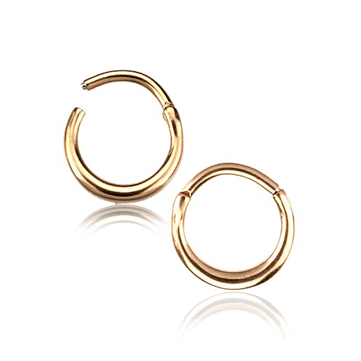 A pair of AMAO Clicker Nose Rings in rose gold from Kaya Movement are shown against a white background. The 16 gauge, 316L surgical steel nose rings have a polished finish, giving them a shiny appearance. They are positioned with one ring slightly above and to the left of the other.