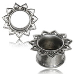 Two ornate, circular silver tunnels intricately designed with a Mandala Lotus flower pattern by Kaya Movement. Each of the NIN Sacred Lotus Flower Round Tunnels, available in gauges from 3mm to 18mm, features symmetrical petal-like shapes radiating outward and detailed carvings on the petals. One tunnel stands upright, showcasing its hollow center, while the other lies flat.