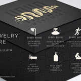 A black box adorned with the Kaya Movement gold snake logo provides "Jewelry Care" tips for your Om Chakra Belly Piercing Ring in Gold (14 gauge). Tips include: remove before showering, swimming, going to the beach or sauna, and engaging in physical activities. Avoid sleeping with it on, keep away from chemicals, and store in its original gift packaging or separated from other jewelry.