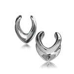 The MYRA Minimalist Saddle Tunnels in Silver by Kaya Movement feature a sleek and modern design with a polished, reflective surface. Displayed against a plain white background, these elegant tunnels range from 10mm to 25mm in gauge and boast a stylish and contemporary appearance due to their symmetrical shape and shiny finish.