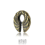 The DAMIER Checkered Hoop Keyhole Ear Weights in Gold from Kaya Movement showcase an intricate design reminiscent of bird wings. Crafted from gold brass and black, they feature a central gap that enhances their elegance against the white background. The branding "Kaya Movement" is subtly displayed below.