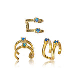 Three LORY Minimalist Ear Cuffs in Gold & Opal from Kaya Movement are displayed against a white background. Each piece features a minimalist design: one with a single double band and two gems, one with a triple band and two gems, and one with a double band and two offset gems.