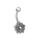 Introducing the Boho Short Belly Button Ring by Kaya Movement, featuring a curved barbell design made of Surgical Steel. This exquisite piece of ethnic body jewelry for navel piercings showcases a shiny silver sphere as the top bead, and a beautifully detailed floral lotus flower charm with a centered clear gemstone at the bottom end.