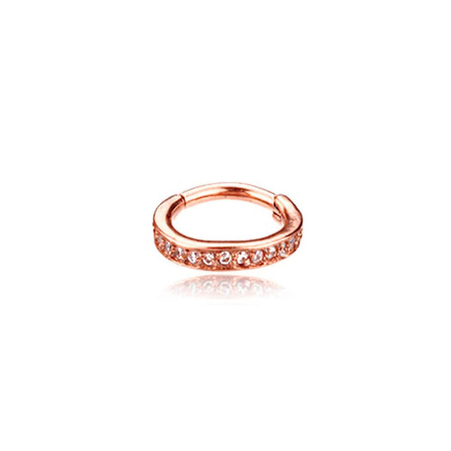 The elegant and minimalist Hinged Septum Ring Clicker 16g Cubic Zirconia by Kaya Movement is a stunning rose gold circular hoop adorned with small, sparkling gemstones along the front half. The ring subtly reflects light as it is placed against a plain white background, casting a slight shadow below.