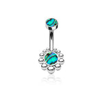 The Bohal Navel Jewelry by Kaya Movement, designed with natural and bohemian elegance, is crafted from 316L surgical steel and features two abalone shell inlays. The larger inlay, encircled by small silver beads forming a flower-like design, embodies the essence of boho navel jewelry flair, while the smaller inlay embellishes the opposite end of the barbell.