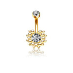Introducing the Kaya Movement's Lustra Navel Piercing, a beacon of contemporary elegance. This geometric design features a small round zircon gem at the top and a larger central zircon gem encircled by a pattern of gold beads at the bottom. Its stainless steel gold finish creates a reflective surface that offers a faint mirroring effect, making it perfect for navel piercings.
