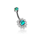 The Kazi Navel Piercing by Kaya Movement is ideal for boho outfits, adorned with a geometric silver design and vibrant abalone shells on both ends. The main part highlights a larger abalone shell encircled by small silver dots, while the other end features a smaller abalone shell. This curved barbell belly button piercing measures gauge 1.6mm (14g) and is 10mm in length, crafted from durable stainless steel.