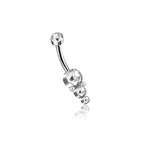 The Kaya Movement Xale 1.6mm Navel Piercing, with its brilliant gold finish, showcases a curved bar adorned with four sparkling zircons arranged in ascending size at one end and a single smaller zircon at the other. This luxurious boho jewelry piece is isolated on a white background.