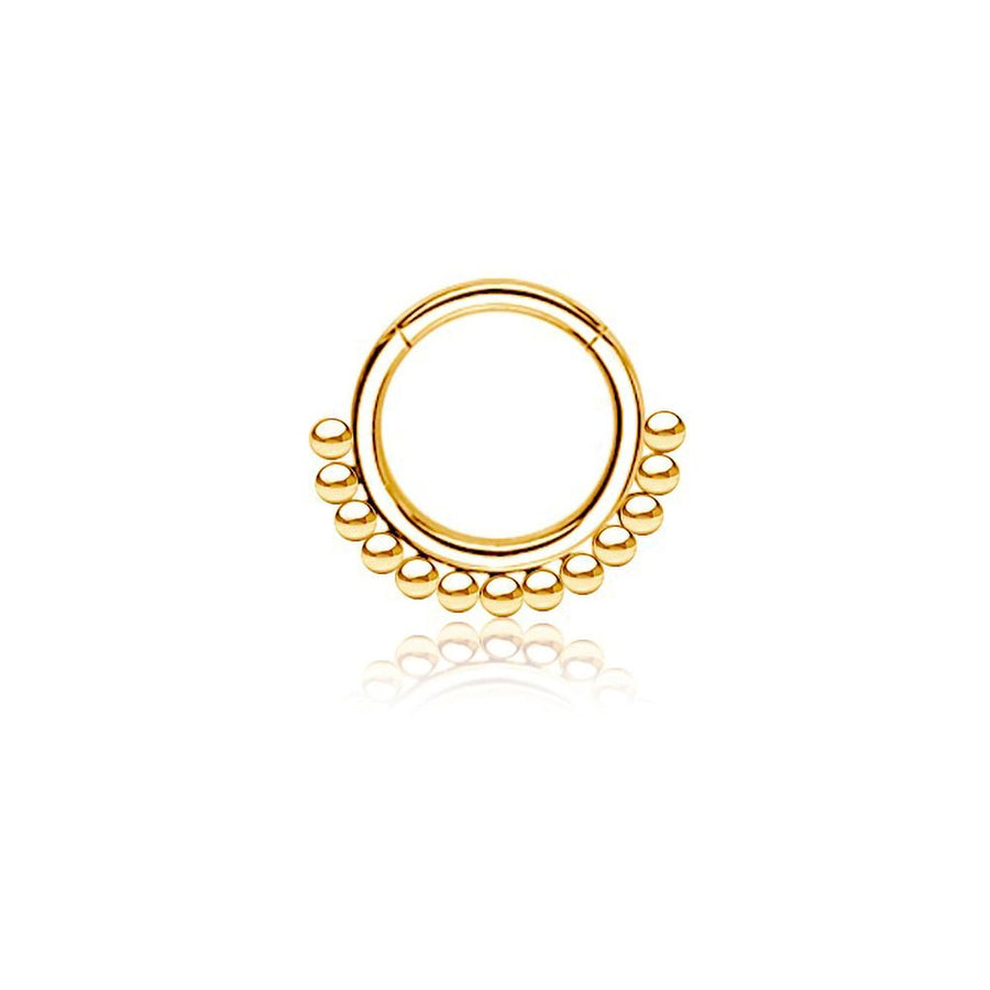 Introducing the "Etna" by Kaya Movement: an elegant and traditional decorative nose ring crafted from 316L Gold PVD Steel. This simple ethnic septum jewelry features a circular design with a row of small, evenly spaced gold beads along the bottom edge. Measuring 1.2mm in gauge and 8mm in diameter, this shiny piece is showcased against a white background, perfectly capturing the essence of ethnic art.