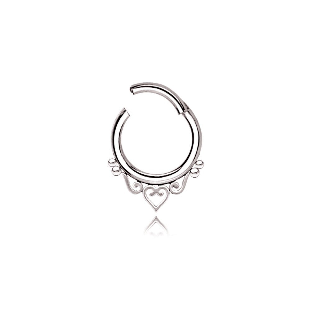 The Kaya Movement's Minimalist Mandala-Inspired Septum in 316L Steel Silver Look "Zura" showcases an intricate design with small loops and a central heart shape. This silver septum ring, available in 1.2mm gauge and diameters of 6mm, 8mm, or 10mm, is open at the top for easy insertion and removal. Against a plain white background, this minimalist jewelry piece truly stands out.