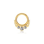 The TriZa Gold PVD Septum with Three Sparkling Zirconias by Kaya Movement is a refined gold hoop earring adorned with small circular designs along the bottom and highlighted by three larger, round sparkling zirconias at the center. The earring is displayed on a white background.