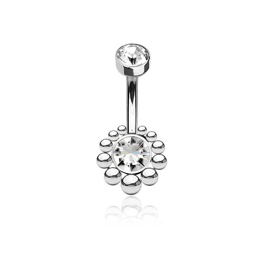 The Zirka Navel Jewelry from Kaya Movement, crafted from 316L surgical steel, features a larger central clear zircon surrounded by small silver beads in a circular pattern. Another smaller clear gemstone adorns the top of the curved silver bar. This Boho Essence navel jewelry, reflecting natural and bohemian elegance, is positioned against a white background.