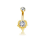 Introducing the Zarina Navel Piercing by Kaya Movement, a bohemian chic accessory with a golden mandala floral design. This elegant piece features a curved barbell adorned with sparkling zircon gemstones—a clear gemstone on one end and an intricate sunburst design encasing another clear gemstone at the other. The reflective craftsmanship and fine details make it a standout addition to any collection.