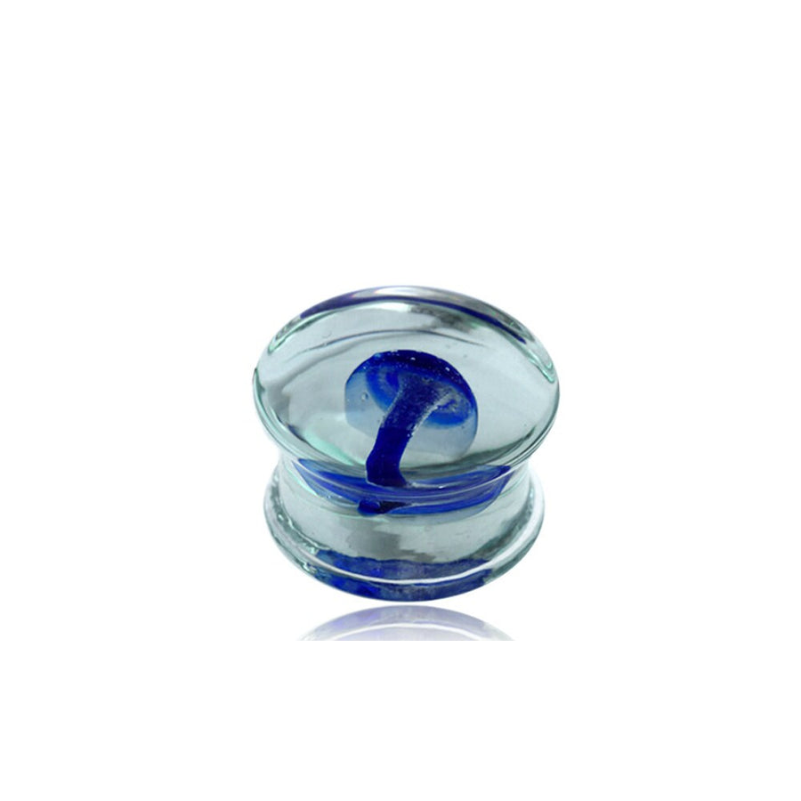 A Psylia Plug by Kaya Movement, designed like a small, clear glass mushroom with a blue stem and a spherical, translucent cap, set against a white background. This Blue Mushroom Glass Design exudes a Psychedelic Festival vibe and is available in sizes ranging from 6mm to 16mm (2g to 5/8").
