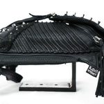 An APOPHIS Post-Apocalyptic Leather Shoulder & Belt Bag in black, adorned with a textured ribbed design and spike embellishments. It features a zipper closure and a small fabric tag displaying the brand name "Kaya Movement." The apocalyptic hip bag is showcased on a white platform with metal supports.